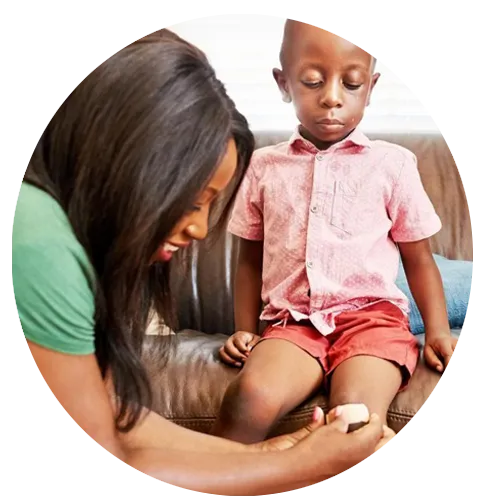 A woman treating a child's scrape.